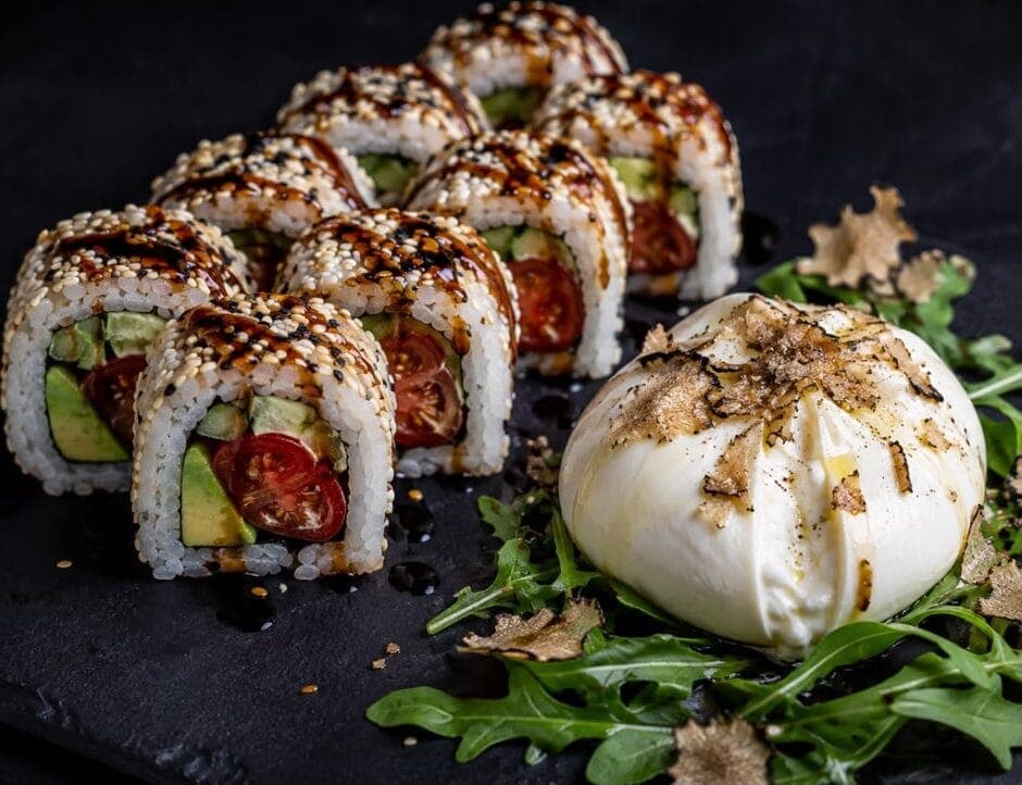 Makis california à l'avocat accompagnés d'une burrata, dressés sur ardoise